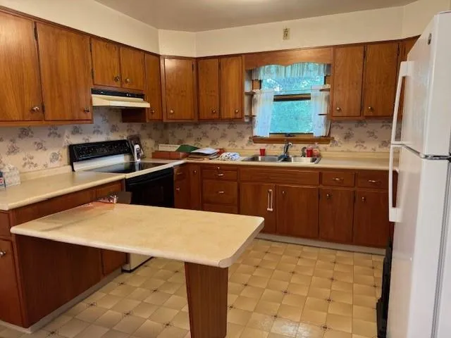 a kitchen with a sink a stove and cabinets