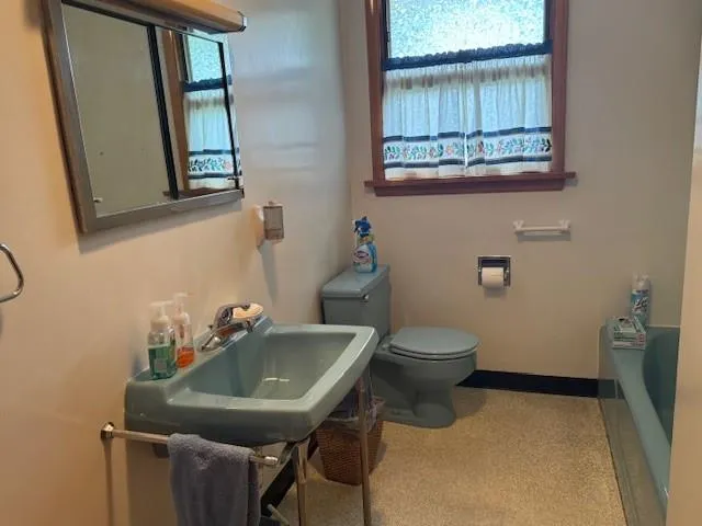 a bathroom with a toilet a sink and a mirror