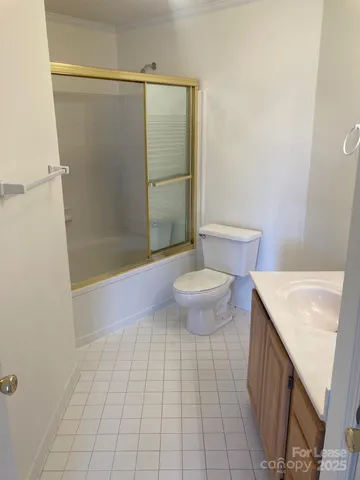 a bathroom with a sink a toilet a mirror and shower