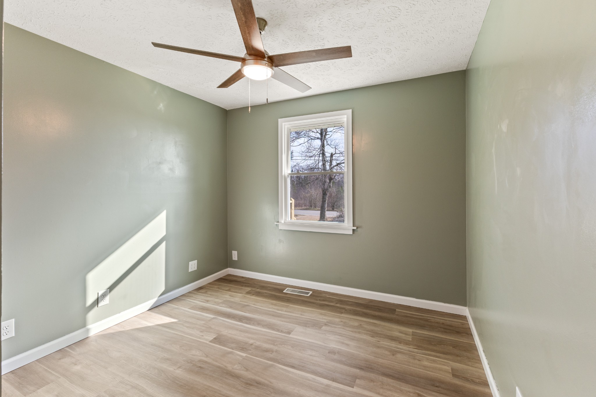 7109 King Road Fairview, TN 37062 - Photo 21 of 26 an empty room with wooden floor fan and windows