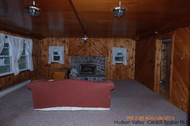 497 County Route 56 Maplecrest, NY 12454 - Photo 9 of 9 a living room with furniture a flat screen tv and a fireplace