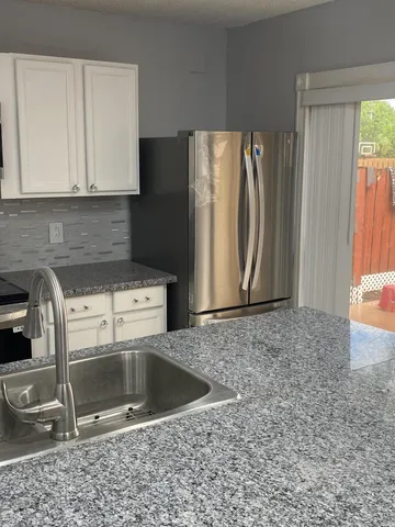 a kitchen with a sink a refrigerator and cabinets