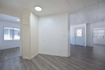 a kitchen with cabinets stove and wooden floor