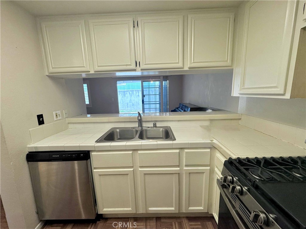 14152 Foothill Boulevard, Unit 35 Sylmar, CA 91342 - Photo 11 of 30 a kitchen with granite countertop a sink stove and cabinets