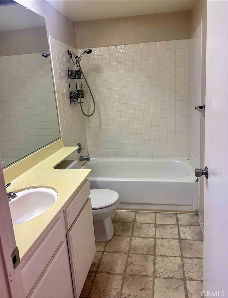 14152 Foothill Boulevard, Unit 35 Sylmar, CA 91342 - Photo 16 of 30 a bathroom with a granite countertop bathtub shower sink and toilet