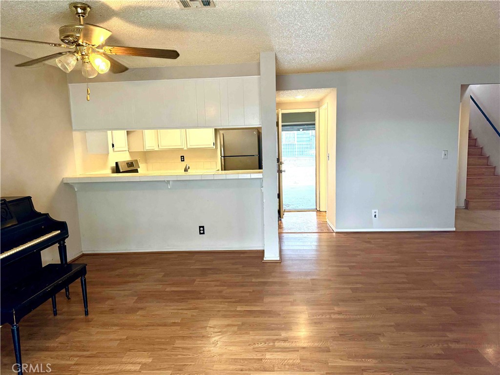 14152 Foothill Boulevard, Unit 35 Sylmar, CA 91342 - Photo 6 of 30 a view of kitchen and empty room with wooden floor