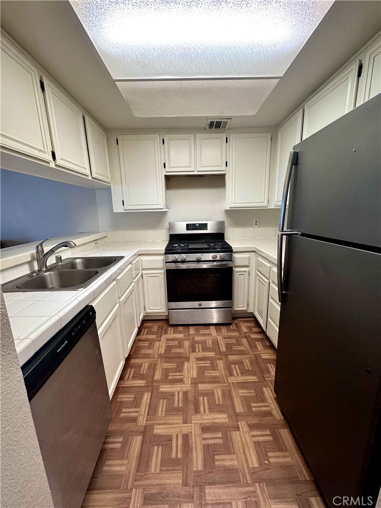 14152 Foothill Boulevard, Unit 35 Sylmar, CA 91342 - Photo 9 of 30 a kitchen with a sink stove and refrigerator