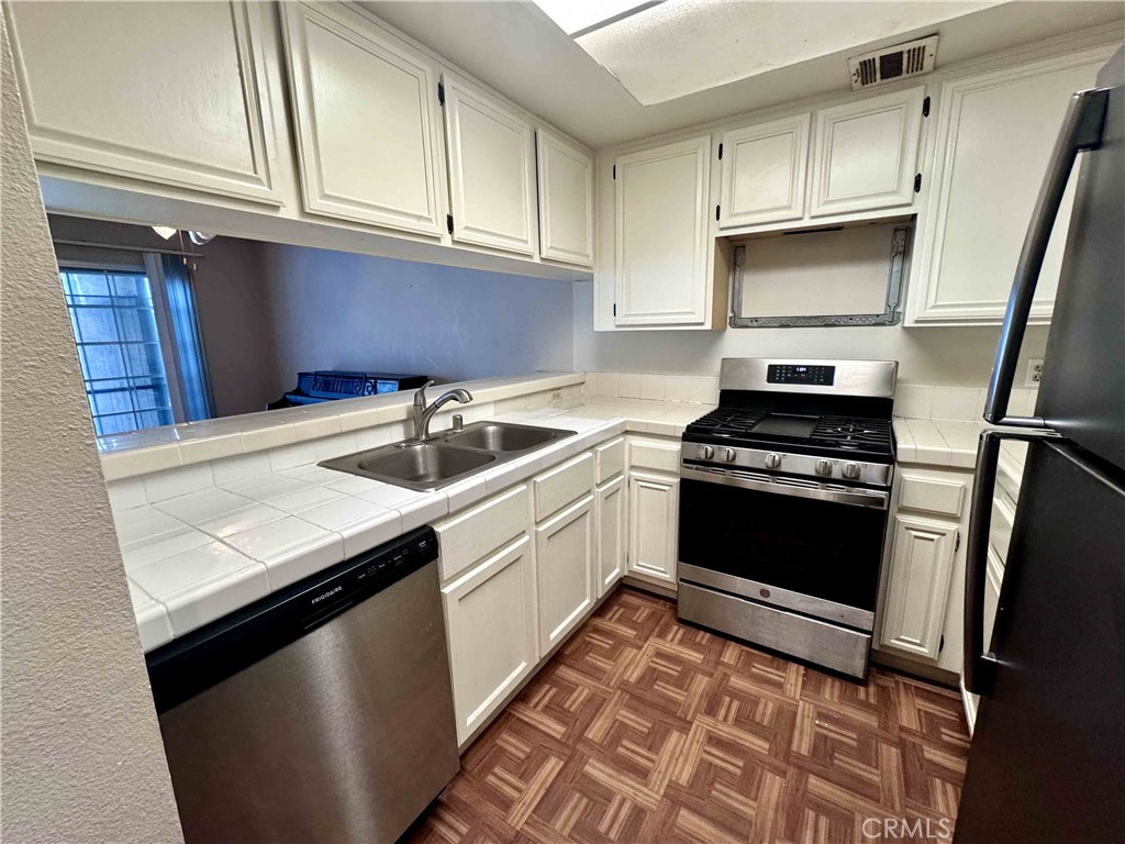 14152 Foothill Boulevard, Unit 35 Sylmar, CA 91342 - Photo 10 of 30 a kitchen with granite countertop a sink stainless steel appliances and cabinets
