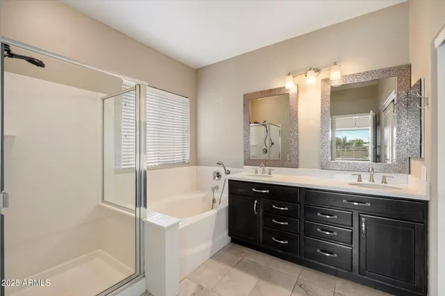 a bathroom with a tub sink double vanity granite and a mirror