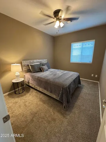 a spacious bedroom with a bed and a chandelier