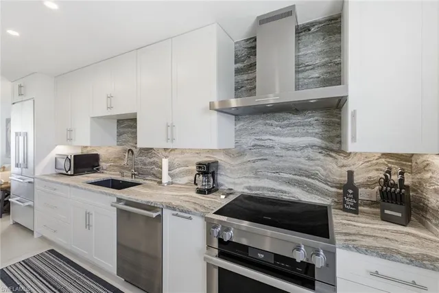 a kitchen with stainless steel appliances granite countertop a stove and a sink