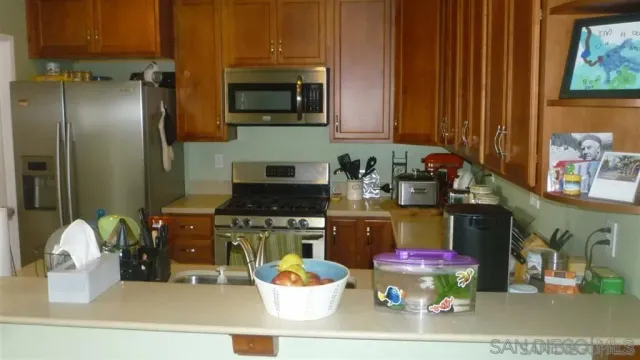 a kitchen with a refrigerator and a stove top oven