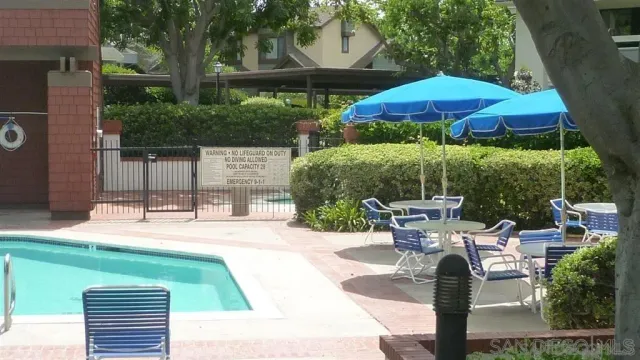 a view of a patio with chairs and table under an umbrella