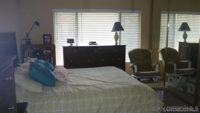 a bedroom with a large bed and windows