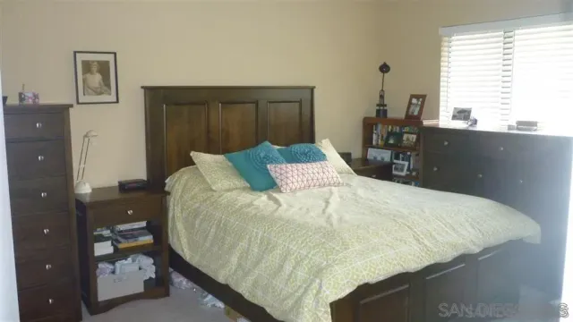 a bed sitting in a bedroom next to a window