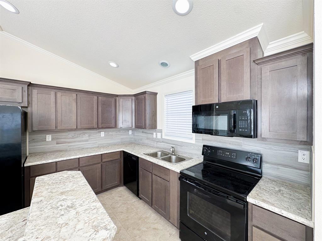 Kitchen featuring L-shaped cabinetry, light-toned countertops, tile backsplash, and recessed lighting