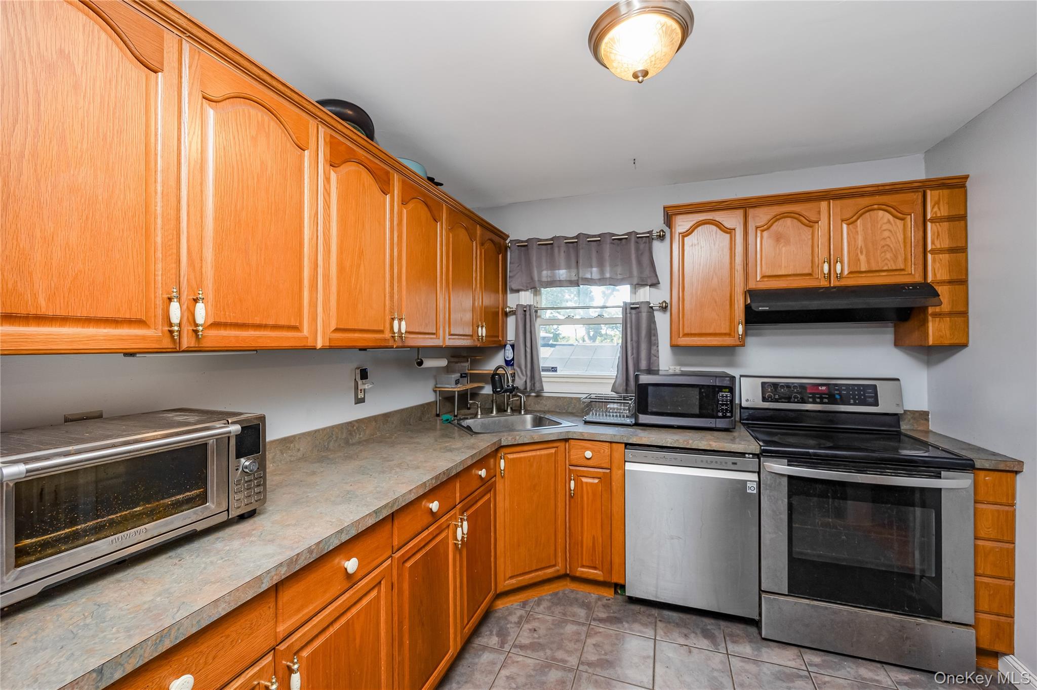 16 Hillside Road Farmingville, NY 11738 - Photo 3 of 22 a kitchen with granite countertop a sink cabinets stainless steel appliances and a window