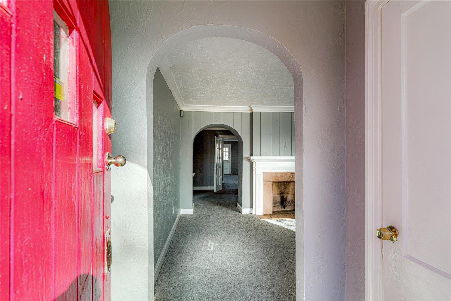 1114 Brownlee Road Memphis, TN 38116 - Photo 5 of 32 Hallway with a textured wall, arched walkways, crown molding, and a textured ceiling