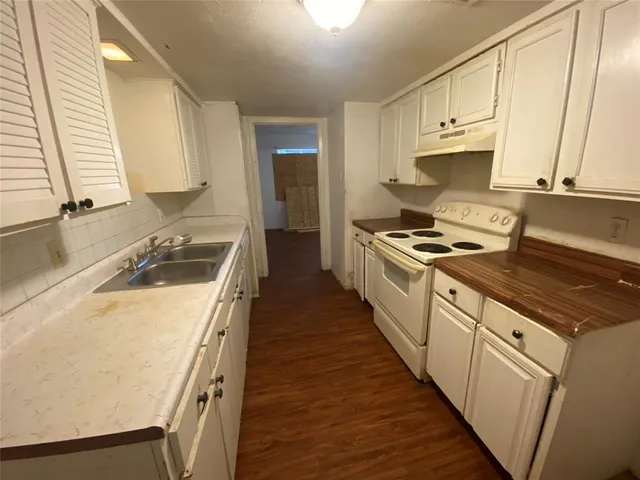 a kitchen with a sink stove top oven and cabinets