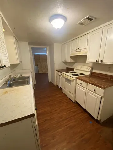a kitchen with granite countertop white cabinets and white appliances
