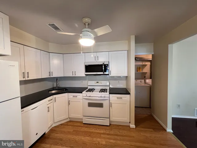 a kitchen with a sink a stove and cabinets