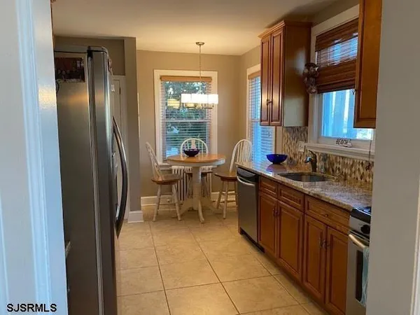 a kitchen with stainless steel appliances granite countertop a sink and a refrigerator