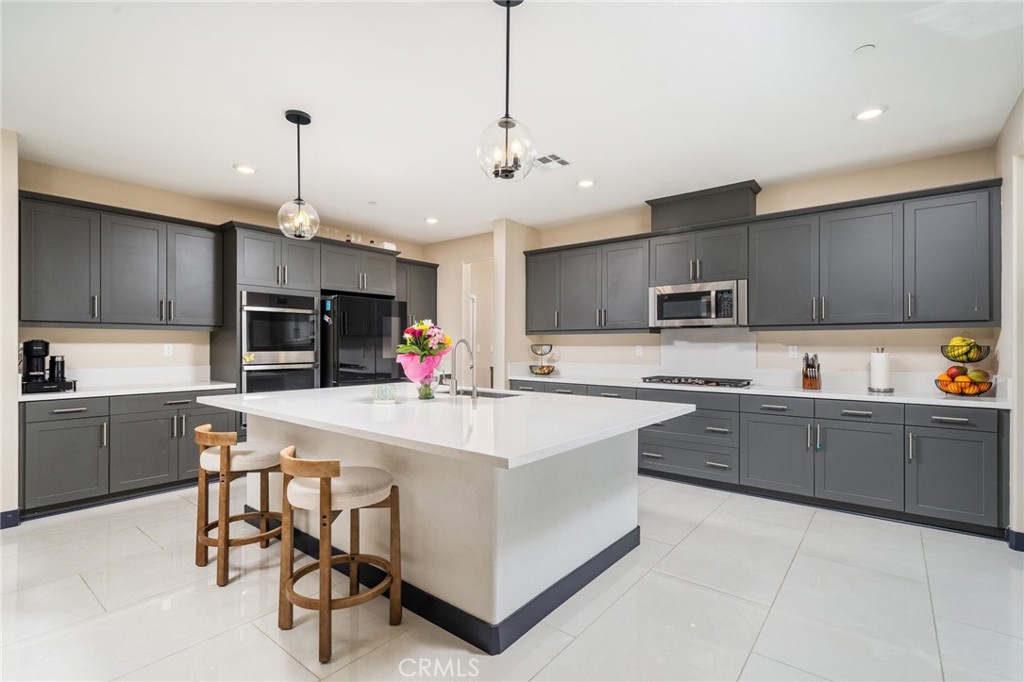 2414 Crater Avenue Rialto, CA 92377 - Photo 10 of 50 a large kitchen with cabinets chairs and white appliances