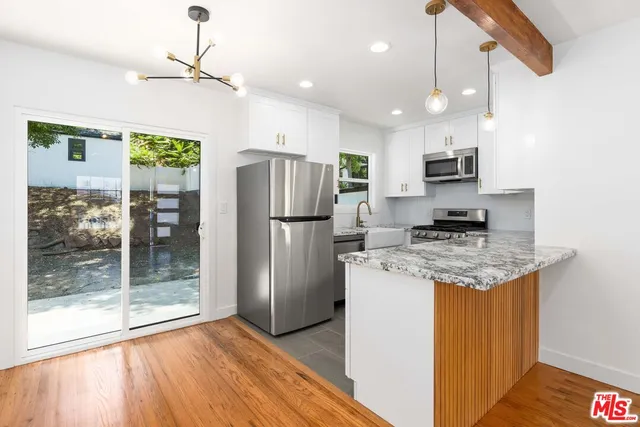 a kitchen with stainless steel appliances granite countertop a refrigerator a stove a sink and a refrigerator