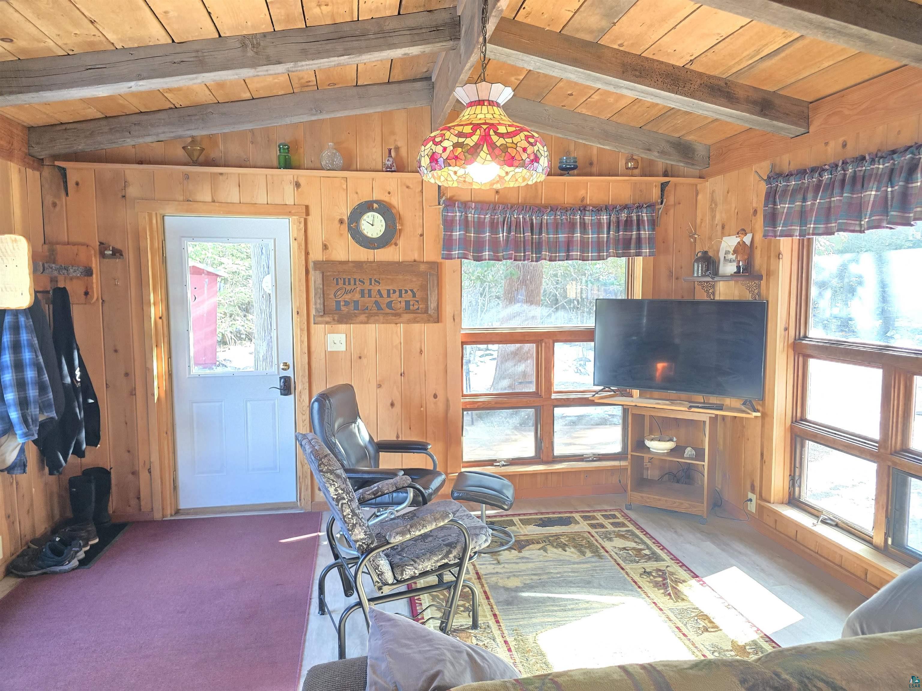 88910 Bark Point Road Herbster, WI 54844 - Photo 12 of 31 Living room with vaulted ceiling with beams, wood walls, carpet, and wood ceiling