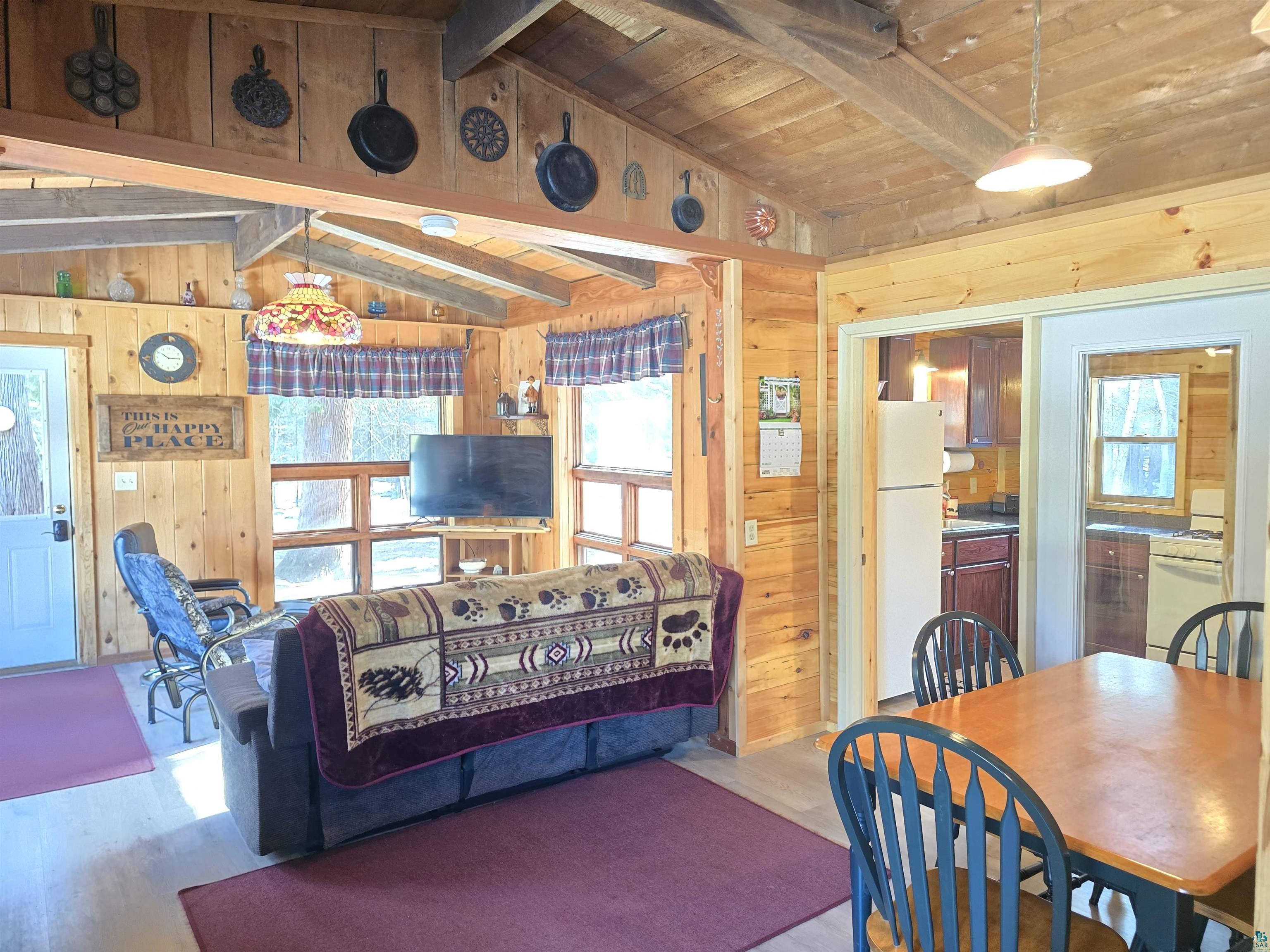 88910 Bark Point Road Herbster, WI 54844 - Photo 15 of 31 Living area with lofted ceiling with beams, wooden ceiling, and wooden walls