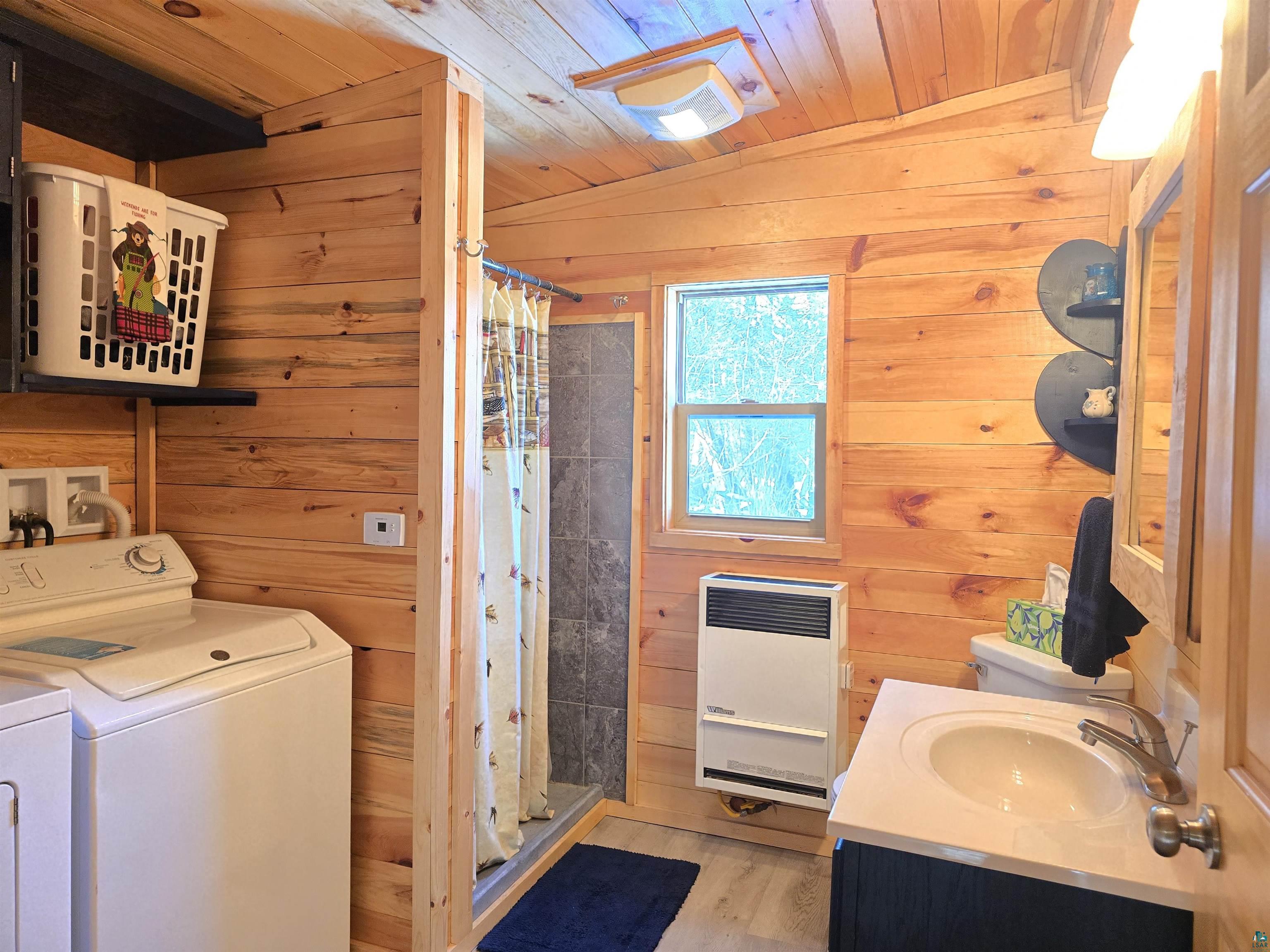 88910 Bark Point Road Herbster, WI 54844 - Photo 23 of 31 Bathroom featuring washer and dryer, wood walls, and heating unit