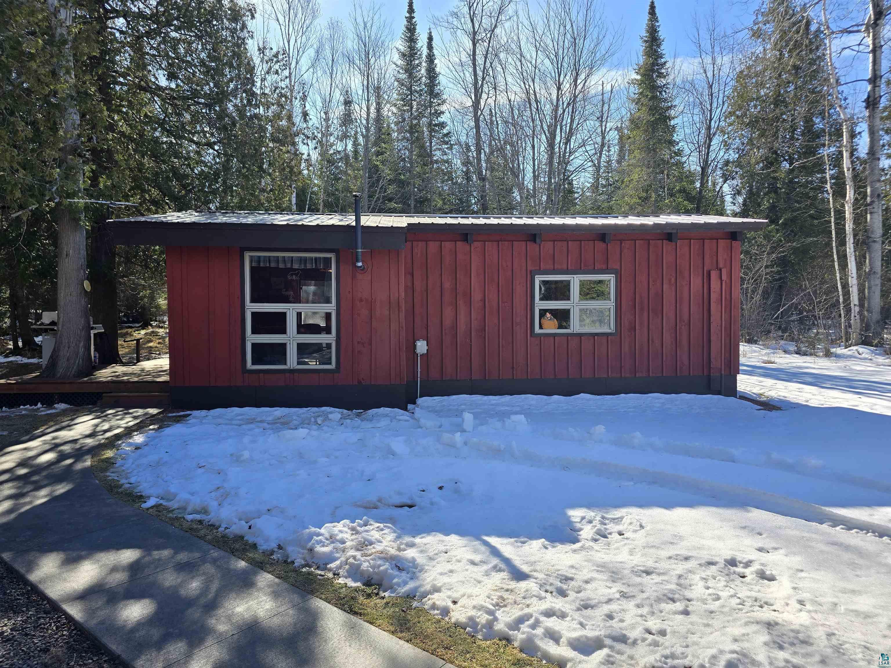 View of front facade featuring metal roof and board and batten siding
