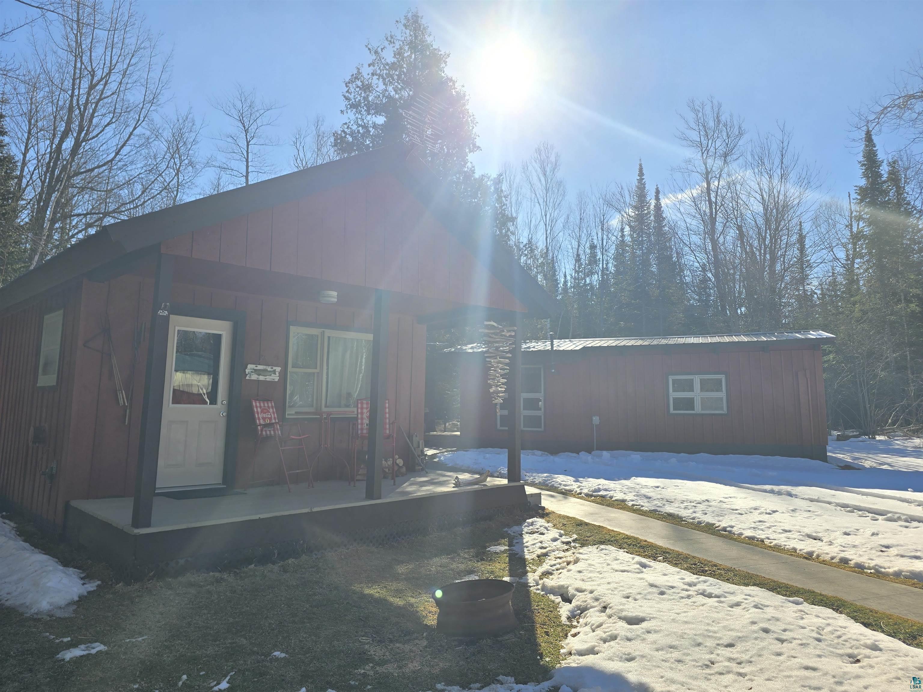 View of front of property with an outbuilding, metal roof, and a porch
