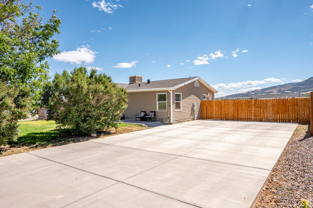 4296 Maple Lane Cedar City, UT 84721 - Photo 3 of 44 Expansive concrete paved area with a perimeter privacy fence and mountain backdrop