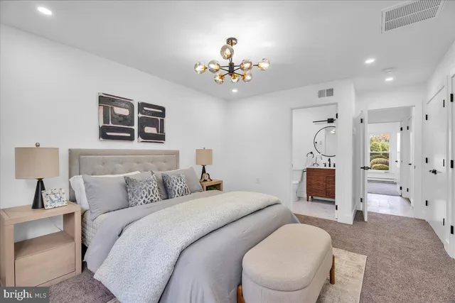 a spacious bedroom with a bed and a chandelier
