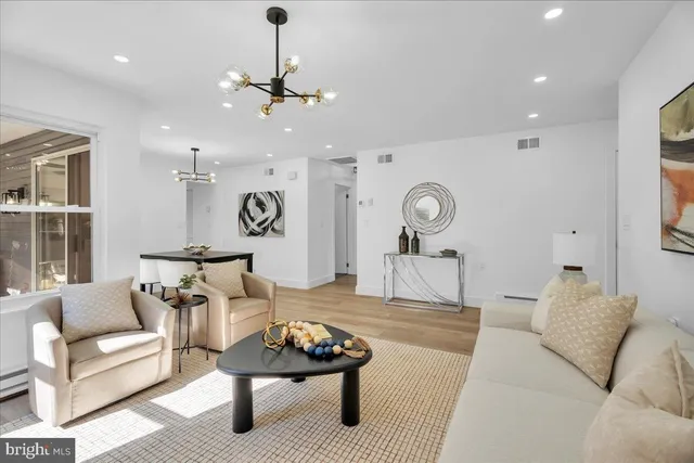 a living room with furniture and a chandelier