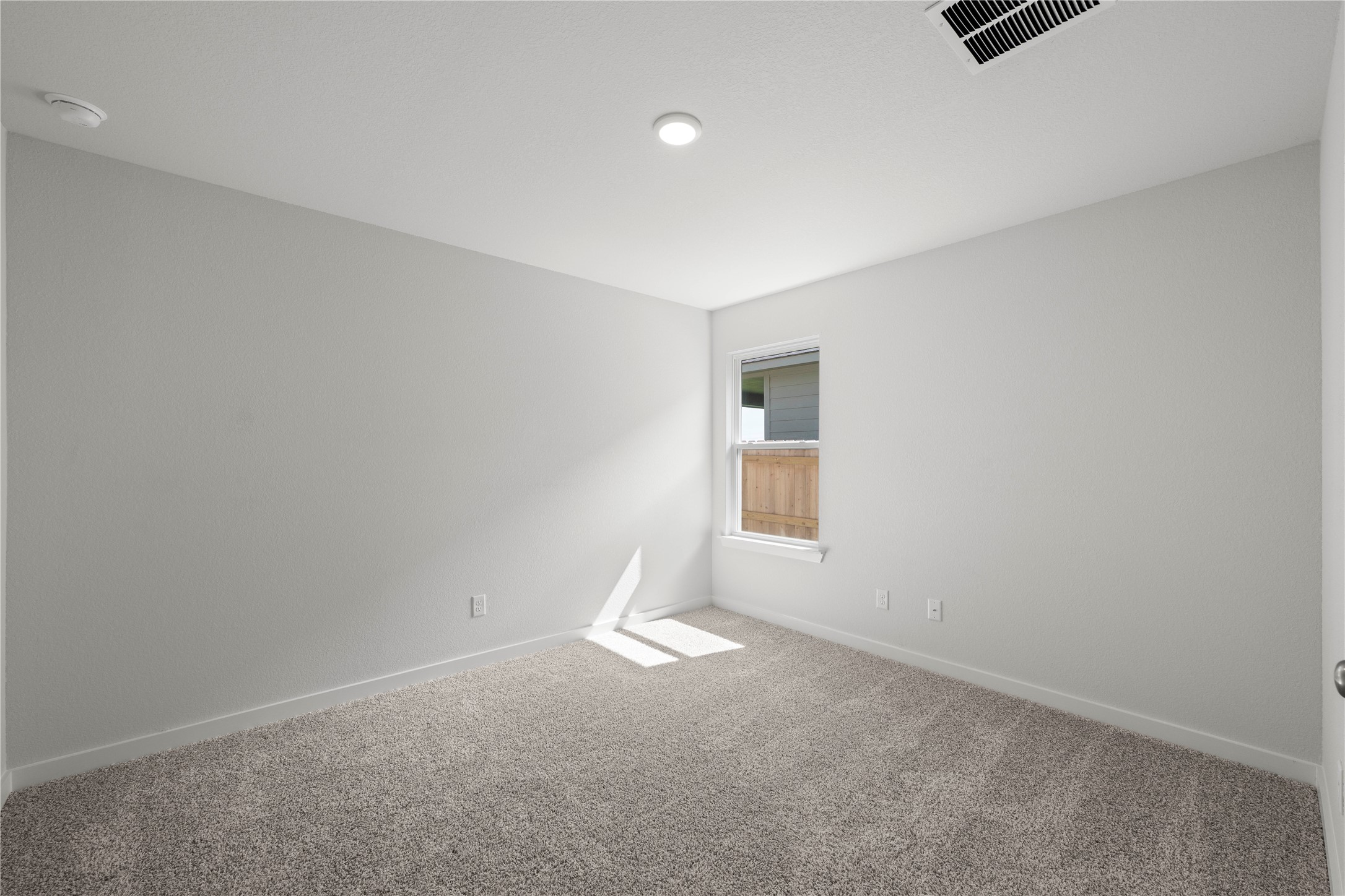 220 Gus Loop Georgetown, TX 78626 - Photo 7 of 18 A well-lit bedroom features plush carpeting, a single window, and a modern overhead light fixture.
