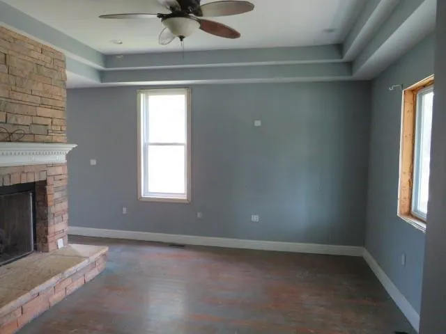 an empty room with a fireplace and windows