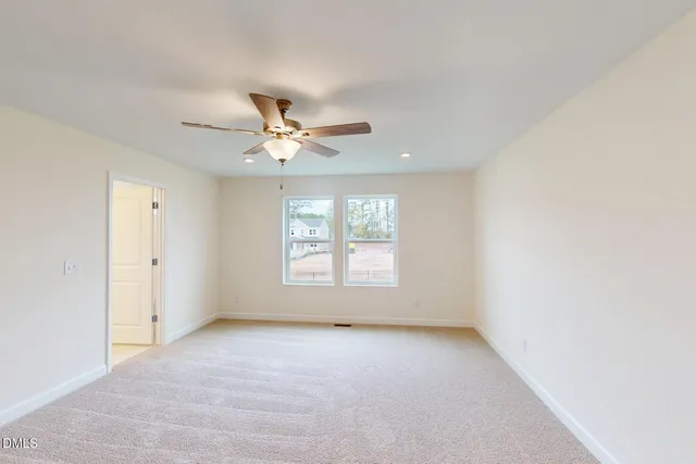 an empty room with a window and a fan