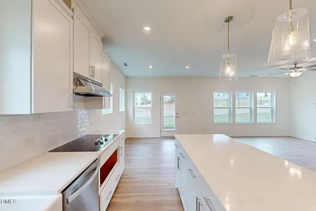 a spacious bathroom with a granite countertop sink a large mirror and a bathtub