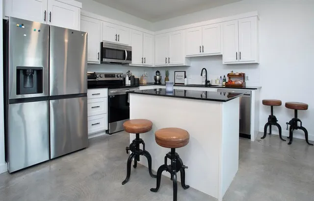 a kitchen with cabinets stainless steel appliances and a sink