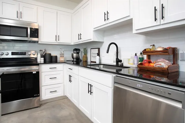 a living room with furniture a kitchen view and a refrigerator