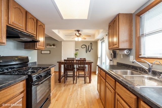 236 Kingsbridge Road Elk Grove Village, IL 60007 - Photo 4 of 13 a kitchen with stainless steel appliances granite countertop a sink stove and cabinets