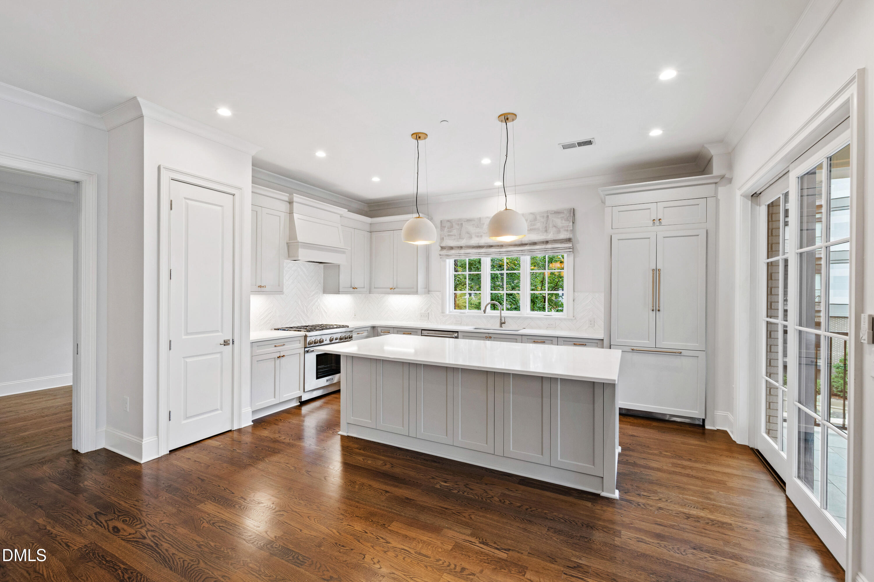 620 Wade Avenue, Unit 103 Raleigh, NC 27605 - Photo 11 of 41 a large kitchen with stainless steel appliances granite countertop a stove a sink dishwasher and a large refrigerator with wooden floor