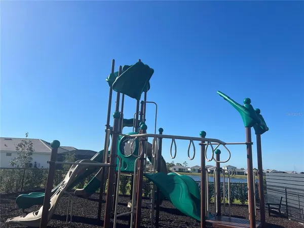a front view of multi story residential apartment building with yard and sign board