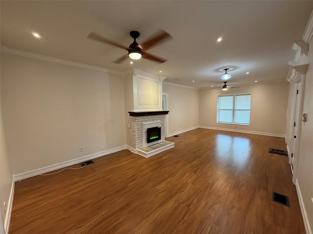 903 East New York Avenue DeLand, FL 32724 - Photo 7 of 29 wooden floor in an empty room with a window