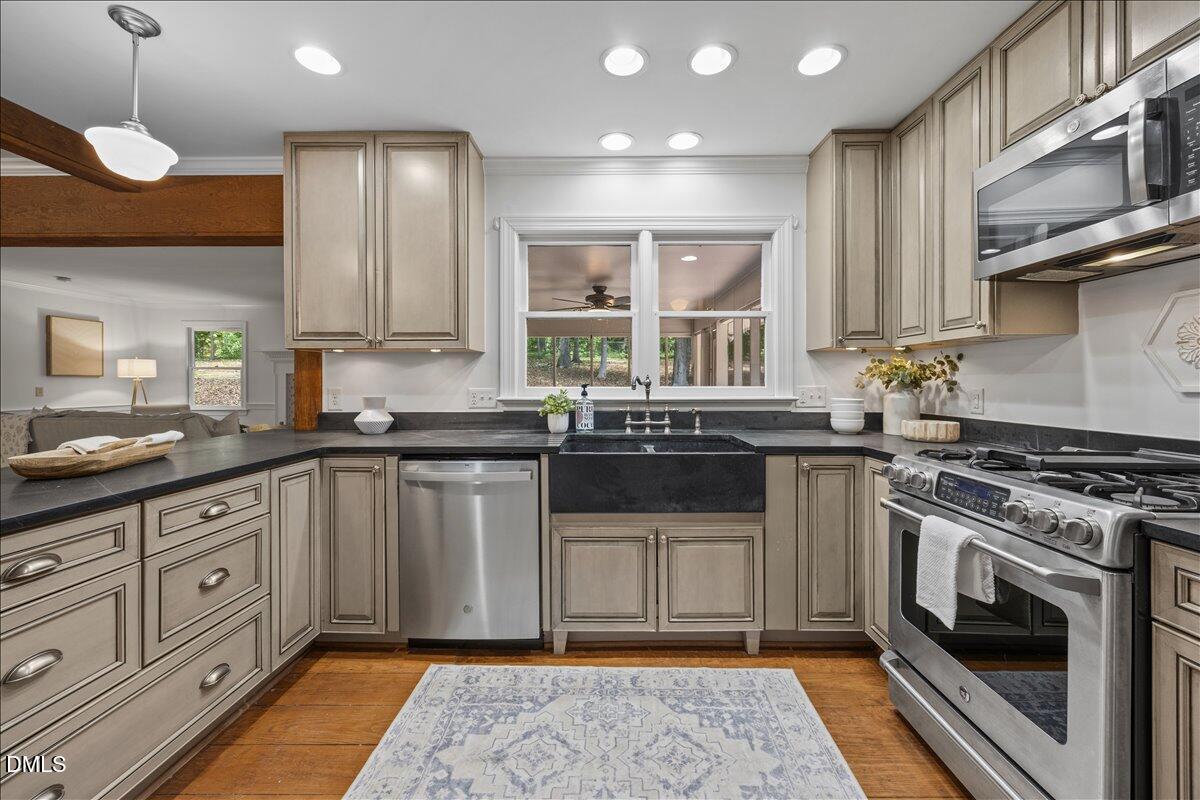 6516 Bakersfield Drive Raleigh, NC 27606 - Photo 9 of 59 a kitchen with stainless steel appliances granite countertop a stove a sink and a microwave