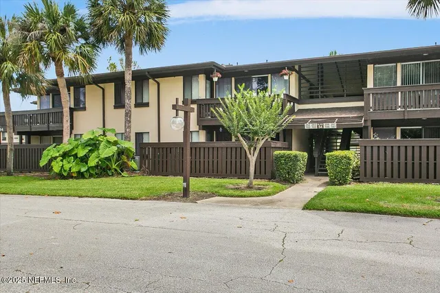 a front view of a house with a yard and potted plants