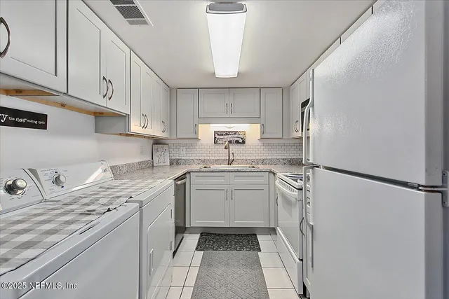 a kitchen with a sink a refrigerator and cabinets