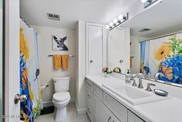 a bathroom with a sink a toilet and a large mirror